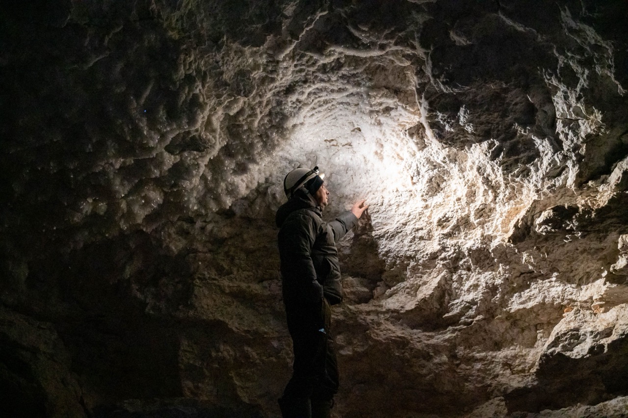 Guide de spéléologie accompagnant un groupe dans une grotte
